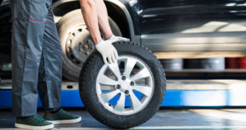 Garagiste prêt à changer une roue, montée avec un pneu neuf